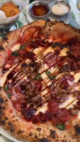 A vlog-style review of a new Pizza Pilgrims location in Glasgow, featuring a tour of the interior, a look at the menu, and a showcase of various dishes including artichoke fritti, cacio e pepe balls, and two different pizzas.