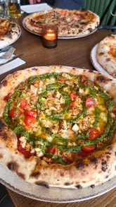 Here are a few options for your SEO alt text, depending on what the image shows:

**Option 1 (Focus on the food - best for general shots):**
Delicious sourdough pizzas from Bistro 66 in Beeston, featuring Pesto Chicken, Old Major, and Il Classico pepperoni.

**Option 2 (Focus on the experience - best for lifestyle shots):**
A family dining on a selection of freshly baked sourdough pizzas at Bistro 66 restaurant in Beeston.

**Option 3 (Short & punchy):**
Gourmet sourdough pizzas including pepperoni and chicken at Bistro 66, a Mediterranean-inspired restaurant in Beeston.

**SEO Tip:** The first option is generally the best for SEO as it includes the specific menu items mentioned in your caption, which helps search engines understand the content of the image.