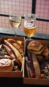 A short, energetic reel showcasing a casual BBQ and drinks event at an outdoor venue. The video features a group of friends enjoying food, drinks, and the atmosphere, highlighting the social nature of the experience.