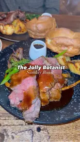 A montage video showcasing a Sunday roast meal and cocktails at The Jolly Botanist, featuring close-ups of the food and drinks.