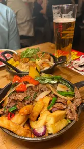 A short, punchy review of the 'Rush Hour' deal at Mans Market, featuring close-ups of various Chinese dishes including gyoza, satay chicken, and sweet and sour chicken, alongside the menu offer.