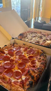 A short, handheld-style video showcasing various pizzas, chicken tenders, and fries from Pikka Pizza. The video focuses on close-up shots of the food, including cheese pulls and dipping sauces, to highlight the quality and appeal of the menu items.