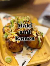 A close-up, shallow depth-of-field shot of a serving of takoyaki on a wooden tray. The image features a prominent text overlay 'Maki and Ramen' centered over the food.