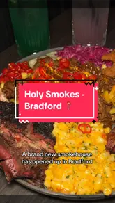 Holy Smokes BBQ restaurant in Bradford, with a delicious spread of smoked meats and sides on a wooden table.