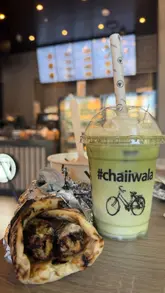 Here are a few options for your SEO alt text, keeping it under 125 characters:

**Option 1 (Descriptive & SEO-focused):**
A variety of Indian street food from Chaiiwala, including a chicken kebab walawrap, loaded masala chips, and matcha tea.

**Option 2 (Focusing on the meal):**
Flat lay of a delicious Chaiiwala meal featuring a chicken sheekh kebab walawrap, loaded chips, and a cinnamon matcha latte.

**Option 3 (Short & punchy):**
Delicious Indian street food spread from Chaiiwala featuring a chicken walawrap, loaded chips, and a sweet matcha drink. 

**SEO Tip:** I included "Indian street food" and "Chaiiwala" in all options, as these are the strongest keywords for your post!