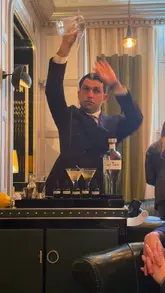 A short, elegant video showcasing the preparation of a martini at The Connaught Bar. The footage focuses on the bartender's precise movements, the selection of bitters, and the signature pouring technique, providing a glimpse into the high-end cocktail experience.