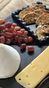 A behind-the-scenes look at a professional food photoshoot featuring various cheeses, crackers, and prepared dishes like a mushroom soup and a salad.