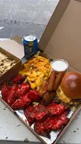 A review of the 'Savage Box' from Smoked 'N' Grill in Newcastle, showcasing a variety of takeaway items including a smash burger, loaded fries, wings, and mozzarella sticks.