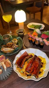 A review of a new Japanese restaurant in Shoreditch, showcasing various dishes including wagyu sando, sushi, grilled unagi, and matcha tiramisu, as well as the interior and upcoming karaoke facilities.