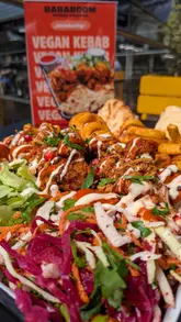 A short, visually-driven review of a vegan kebab dish, focusing on the texture and presentation of the plant-based chicken, curly fries, and salad.