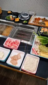 Here are a few options for your SEO alt text, keeping it under 125 characters:

**Option 1 (Descriptive):**
Delicious all-you-can-eat Korean hotpot and BBQ spread with various meats and sides at Yo Fresh in Leicester.

**Option 2 (Action-oriented):**
Diners enjoying a selection of meats, seafood, and sushi at Yo Fresh Korean hotpot and BBQ buffet in Leicester.

**Option 3 (Concise):**
Table full of fresh ingredients, meats, and hotpot soup bases at Yo Fresh restaurant in Leicester.