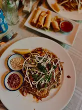 Here are a few options for your SEO alt text, depending on what is shown in the image:

**Option 1 (Focus on the food - best for SEO):**
Delicious Pad Thai and crispy spring rolls served at The White Elephant cafe in Kingswood, Bristol.

**Option 2 (Focus on the venue):**
Interior view of The White Elephant cafe in Kingswood, a hidden gem serving Thai food and English breakfast.

**Option 3 (Short & descriptive):**
Close-up of authentic Pad Thai and spring rolls at The White Elephant restaurant in Kingswood, Bristol.

**SEO Tip:** Since alt text is primarily for accessibility and search engines, it's best to include the **business name**, **location (Kingswood/Bristol)**, and **the specific food/vibe** shown.