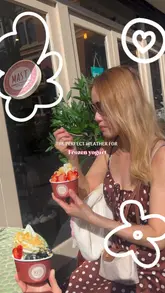 Here are a few options for your SEO alt text, keeping under the 125-character limit:

**Option 1 (Descriptive & SEO-focused):**
A person holding a cup of Mast Frozen Yogurt topped with fresh fruit outside in the sun on King Street West, Manchester.

**Option 2 (Action-oriented):**
Close-up of a delicious Mast Greek frozen yogurt bowl with fresh berries and toppings on a sunny day in Manchester.

**Option 3 (Concise):**
Refreshing Mast Greek frozen yogurt with fresh fruit toppings held outdoors on a sunny day at 31-33 King Street West.

**SEO Tip:** Including the location ("Manchester") and the brand name ("Mast Frozen Yogurt") is excellent for helping local customers find your images in search results.