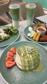 Here are a few options for your SEO alt text, keeping under the 125-character limit:

**Option 1 (Descriptive & SEO-focused):**
"Pistachio soufflé pancakes and brunch dishes served at Sipping Boba in Market Square."

**Option 2 (Action-oriented):**
"Close up of fluffy Japanese soufflé pancakes and brunch at Sipping Boba in Market Square."

**Option 3 (Keyword-rich):**
"Halal brunch, savory croffles, and Japanese soufflé pancakes at Sipping Boba in Market Square."

**Recommendation:** Use **Option 1** if the image focuses on the pancakes, or **Option 3** if it's a shot of the full table spread.