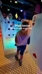 A promotional video for 'Mission: Mad Hatter' at Z-arts in Manchester, featuring children participating in an Alice in Wonderland-themed escape room. The video highlights the interactive puzzles, digital elements, and immersive set design.
