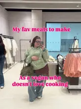 A mirror selfie taken in a clothing retail store with text overlay discussing vegan meal ideas. The image does not feature any food, drink, or hospitality venue.