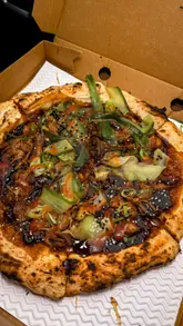 Here are a few options for your SEO alt text, depending on the specific image:

**Option 1 (Focus on the food variety - best for a photo of all items):**
A selection of gourmet Fusion Pizza specials, including Hoisin Duck and Creamed Mushroom pizzas, served in Neath.

**Option 2 (Focus on the standout dish):**
Close-up of a Hoisin Duck pizza with spring onion and sesame from Fusion Pizza in Neath, South Wales.

**Option 3 (General/Brand-focused):**
Gourmet stone-baked pizzas and a chocolate brownie on a table at Fusion Pizza in Neath, South Wales. 

**SEO Tip:** I have included the location (**Neath**) and the brand name (**Fusion Pizza**), as these are the most important elements for local search discovery.