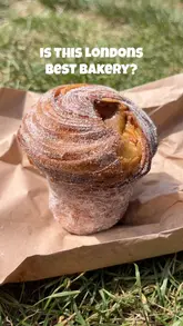 A short, punchy review of Frankie's Bakery in Chiswick, London. The video features a queue outside the shop, a look at the display case, and close-ups of various pastries and sandwiches, including a cinnamon bun and a cruffin, accompanied by a voiceover review.