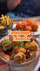 Here are a few options for your alt text, keeping SEO and descriptive best practices in mind:

**Option 1 (Descriptive & SEO focused):**
A colourful spread of Indian dishes including paneer, chaat bombs, and naan at Tamatanga restaurant in Leicester.

**Option 2 (Action-oriented):**
Close-up of a delicious Indian dinner feast with mocktails at the vibrant Tamatanga restaurant in Leicester.

**Option 3 (Concise):**
Table full of Indian sharing plates and a Goan Temple mocktail at Tamatanga restaurant in Leicester city centre.

**SEO Tip:** I included "Tamatanga" and "Leicester" in all options, as these are the most important keywords for local search rankings.