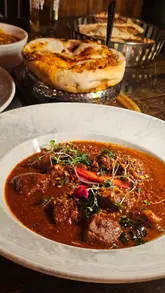 A review of Nutmeg in Clifton, Bristol, featuring a variety of Indian dishes including goat champaran, lamb cutlets, and vindaloo, alongside beer.