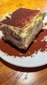 Here are a few options for your alt text (all under 125 characters):

* **Option 1 (Descriptive):** A creamy, cocoa-dusted tiramisu served in a glass bowl at Sugo Pasta in Glasgow.
* **Option 2 (Action-oriented):** Close-up of a delicious homemade tiramisu dessert from Sugo Pasta restaurant in Glasgow.
* **Option 3 (SEO-focused):** Traditional Italian tiramisu with cocoa powder served at Sugo Pasta, a popular restaurant in Glasgow.