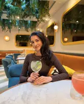 A high-quality, well-composed portrait of a customer enjoying a cocktail at Dottie's Restaurant, highlighting the venue's modern, inviting interior and relaxed atmosphere.