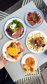 Here are a few options for your SEO alt text, keeping it under 125 characters:

**Option 1 (Descriptive & SEO-focused):**
A delicious brunch spread at Half Cup London featuring chocolate chip pancakes, avocado toast, and savory nduja pancakes.

**Option 2 (Action-oriented):**
Fresh summer brunch menu items at Half Cup London, including stacked pancakes, avocado toast, and nduja flatbread.

**Option 3 (Short & punchy):**
A table full of gourmet brunch dishes, including chocolate pancakes and avocado toast at Half Cup in Kings Cross, London.