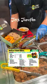 Here are a few options for your SEO alt text (all under 125 characters):

**Option 1 (Focus on description):**
Loaded bowl of jerk chicken, curry goat, rice and peas, plantain, and mac and cheese from Jerk Junction at Trinity Kitchen.

**Option 2 (Focus on location and brand):**
A delicious, overflowing Caribbean food bowl from Jerk Junction at Trinity Kitchen, featuring jerk chicken and curry goat.

**Option 3 (Concise):**
Close-up of a hearty Jerk Junction Caribbean food bowl with jerk chicken, curry goat, mac and cheese, and fried plantain.

**SEO Tip:** I recommend **Option 1** as it includes the specific location (Trinity Kitchen) and the key menu items, which helps search engines categorize the food and the place.