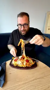 A food review video featuring a creator visiting 'Cross Bar' in Wakefield, showcasing their smash burger, loaded pizza fries, and kids' menu options, while highlighting the venue's family-friendly facilities like a soft play area and sports pitch.
