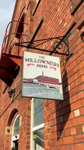 Here are a few options for your alt text, keeping within the 125-character limit:

**Option 1 (Descriptive):**
Cosy interior of The Millowners Arms pub in Sheffield featuring industrial decor, beer taps, and a warm, inviting vibe.

**Option 2 (Action-focused):**
A person enjoying a pint at The Millowners Arms in Kelham Island, Sheffield, a charming pub with industrial heritage.

**Option 3 (SEO-focused):**
The Millowners Arms, a dog-friendly pub in Kelham Island, Sheffield, known for its industrial charm and beer selection.

**Recommendation:** Option 1 is generally the best for accessibility and SEO as it describes the visual elements of the space clearly.