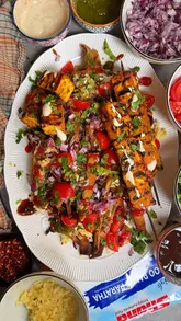 Here are a few SEO-friendly alt text options under 125 characters:

**Option 1 (Descriptive & SEO focused):**
Crispy aloo paratha strips topped with melted cheese, yoghurt, chutney, onions, and coriander on a white plate.

**Option 2 (Action-oriented):**
A delicious plate of loaded aloo paratha fries topped with tangy sauces, melted cheese, and fresh herbs.

**Option 3 (Short & punchy):**
Loaded crispy aloo paratha fries served with yoghurt, chutneys, and melted cheese as a desi street food snack.

**SEO Tip:** Option 1 is generally the best for accessibility and search engines as it clearly describes the visual components of the dish.