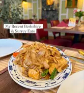 A casual, snapshot-style image of a plate of stir-fried noodles, likely Pad Thai, served in a restaurant setting. The image includes a large text overlay indicating it is part of a listicle of recent food experiences.