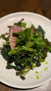 A detailed review of a dining experience at Saddle & Spoke, located within the Stratton House Hotel in Biggleswade. The creator provides a walkthrough of the venue, starting with cocktails and moving through a variety of starters and mains, including scallops, Korean fried chicken, lamb rump, and tandoori monkfish, concluding with a dessert.