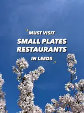 A bright, aesthetic image of cherry blossom branches against a blue sky, serving as a background for a text-based listicle recommending small plates restaurants in Leeds.