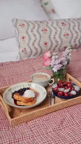 A polished lifestyle video featuring a woman preparing French toast with berries and relaxing in a luxury Vispring bed, focusing on the comfort of a slow morning.
