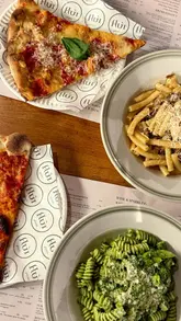 A promotional video for Flùr, a pizza and pasta bar located within the Bonnie & Wild market in Edinburgh. The video features close-up shots of various pizza slices, pasta dishes, and cocktails, along with a brief exterior shot of the venue.