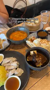 Here are a few options for your alt text, depending on what is most prominent in your photo:

**Option 1 (Focus on the food - Best for SEO):**
Delicious aubergine and tofu with satay sauce served at Satu Satu Malaysian restaurant in Glasgow.

**Option 2 (Focus on the restaurant experience):**
A table full of incredible Malaysian food at Satu Satu restaurant near Charing Cross in Glasgow.

**Option 3 (Concise):**
Tasty Malaysian dishes and artwork at Satu Satu restaurant in Glasgow.

**SEO Tip:** I recommend **Option 1** because it includes the specific dish name and location, which are the most relevant keywords for someone searching for food in Glasgow.