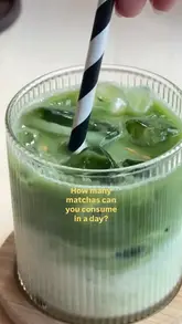 A clean, close-up shot of an iced matcha latte served in a ribbed glass with a black and white striped straw, featuring a text overlay asking about daily matcha consumption.