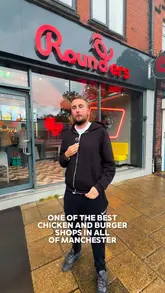 The video features a creator visiting Rounders in Urmston to promote a giveaway of 100 free burgers. The creator introduces the venue, showcases the 'Hungry Box' sharing platter, and provides a close-up review of a beef burger and a chicken burger, highlighting the quality and the dipping experience.
