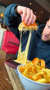 A creator reviews the 'Burger Sizzler' special at Ruby's, featuring a cheeseburger served on a hot sizzling plate with a mozzarella cheese melt and bacon crumb. The video highlights the visual appeal of the cheese pull and the value of the meal.