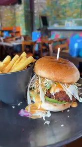 A quick-cut montage showcasing a lunch visit to Las Iguanas, featuring various dishes including nachos, fajitas, a burger, and a katsu curry, alongside cocktails.