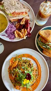 A creator visits Homegrown Garden Centre, highlighting the cafe's brunch and lunch menu before taking a tour of the homeware and plant sections. The video features close-ups of various dishes and the shop's interior.