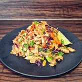 Here are a few options for your SEO alt text, keeping it under 125 characters:

**Option 1 (Descriptive & SEO focused):**
A homemade chicken and vegetable Pad Thai noodle dish served in a bowl for a healthy weeknight meal.

**Option 2 (Action-oriented):**
A healthy, protein-packed chicken and veggie Pad Thai noodle stir-fry served in a ceramic bowl.

**Option 3 (Simple & direct):**
A delicious bowl of chicken and vegetable Pad Thai noodles as part of a healthy meal plan. 

**SEO Tip:** The best alt text describes exactly what is in the image while naturally including keywords like "chicken," "Pad Thai," and "healthy meal.