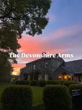 A high-quality, atmospheric exterior shot of The Devonshire Arms at sunset, effectively setting a mood for the venue.