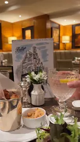 A montage of clips showcasing the interior, food, and retail products at Bettys Cafe Tea Rooms. The video highlights the classic decor, table service, and various menu items like sandwiches, eclairs, and cakes, ending with a look at the gift shop items.
