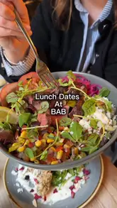 A creator visits BAB to review their new spring menu, showcasing various dishes including a steak bowl, chicken skewers, and a burger. The video provides a tour of the venue and highlights the lunch menu and small plates offering.