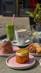 A short vlog featuring a visit to Heidi Bakery in Chelsea. The creator shows the interior, the selection of pastries, and enjoys a breakfast/brunch outside with a friend, highlighting the friendly service and quality of the food.