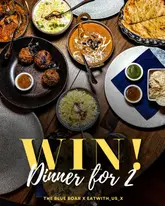 A high-quality, overhead flat-lay shot of an Indian meal spread, including curries, rice, naan, and poppadoms, used to promote a giveaway for a dinner for two.