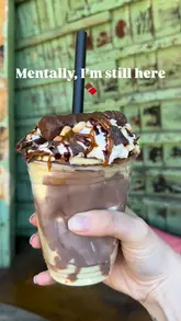 The video features a visit to a chocolate shop where the creator demonstrates the 'pick your own' chocolate station, selecting various chocolate pieces with tongs, weighing them, and then showcasing a 'cracking' milkshake topped with these chocolates.
