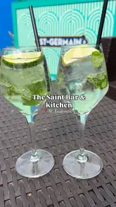 A short, montage-style video showcasing the outdoor seating area, cocktails, and food menu at The Saint Bar & Kitchen in St Andrews. The video features quick cuts of various dishes including a crayfish roll, fried chicken burger, and starters, set to music.